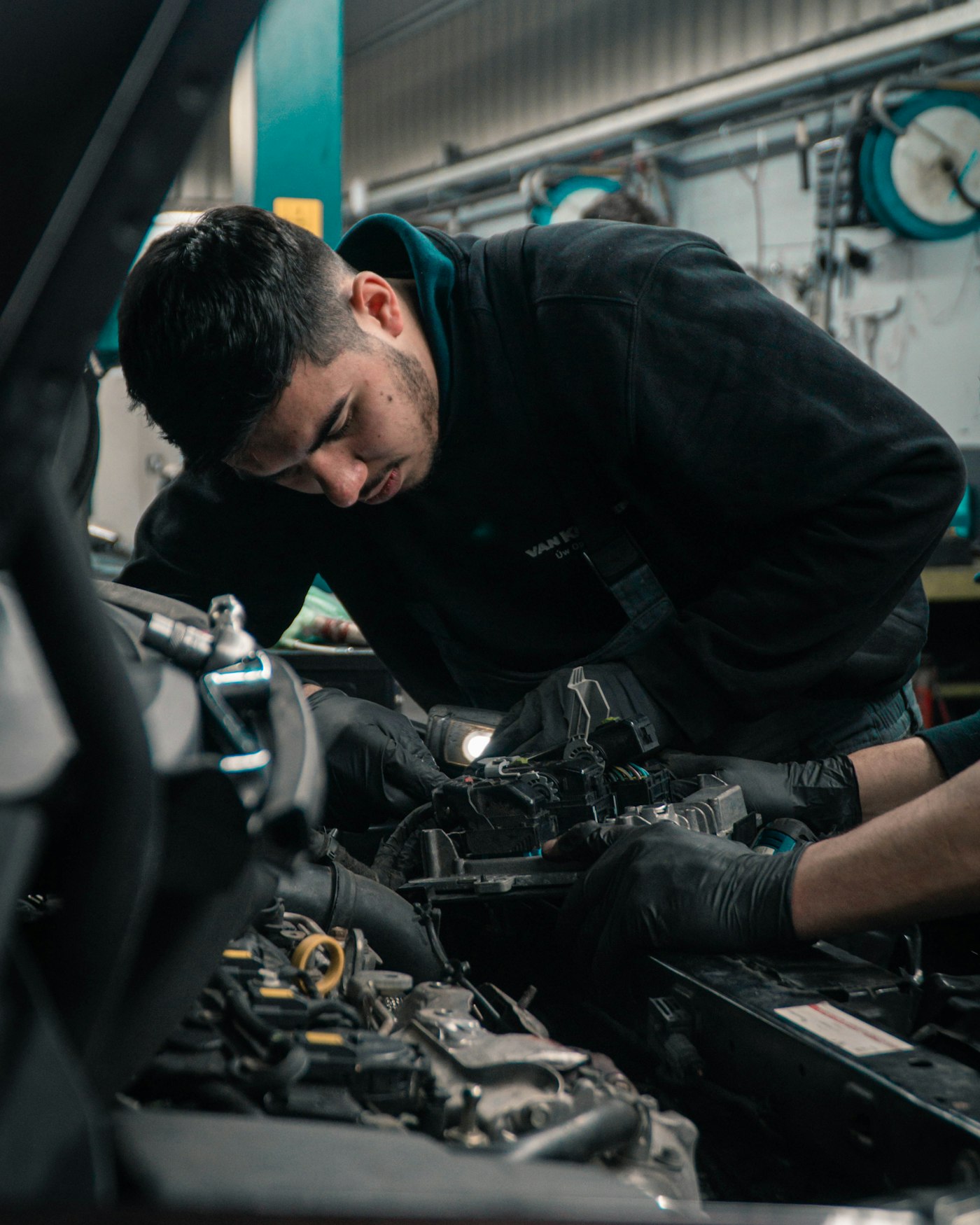 Mechaniker bei der Arbeit am Motor eines Fahrzeugs in der Werkstatt